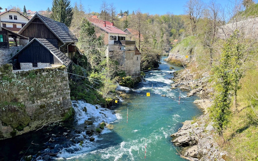 Rastoke Village river with traditional stone and wooden houses, part of the Plitvice Lakes tour.