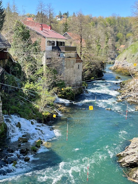Rastoke Village river with traditional stone and wooden houses, part of the Plitvice Lakes tour.