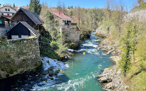 Rastoke Village river with traditional stone and wooden houses, part of the Plitvice Lakes tour.