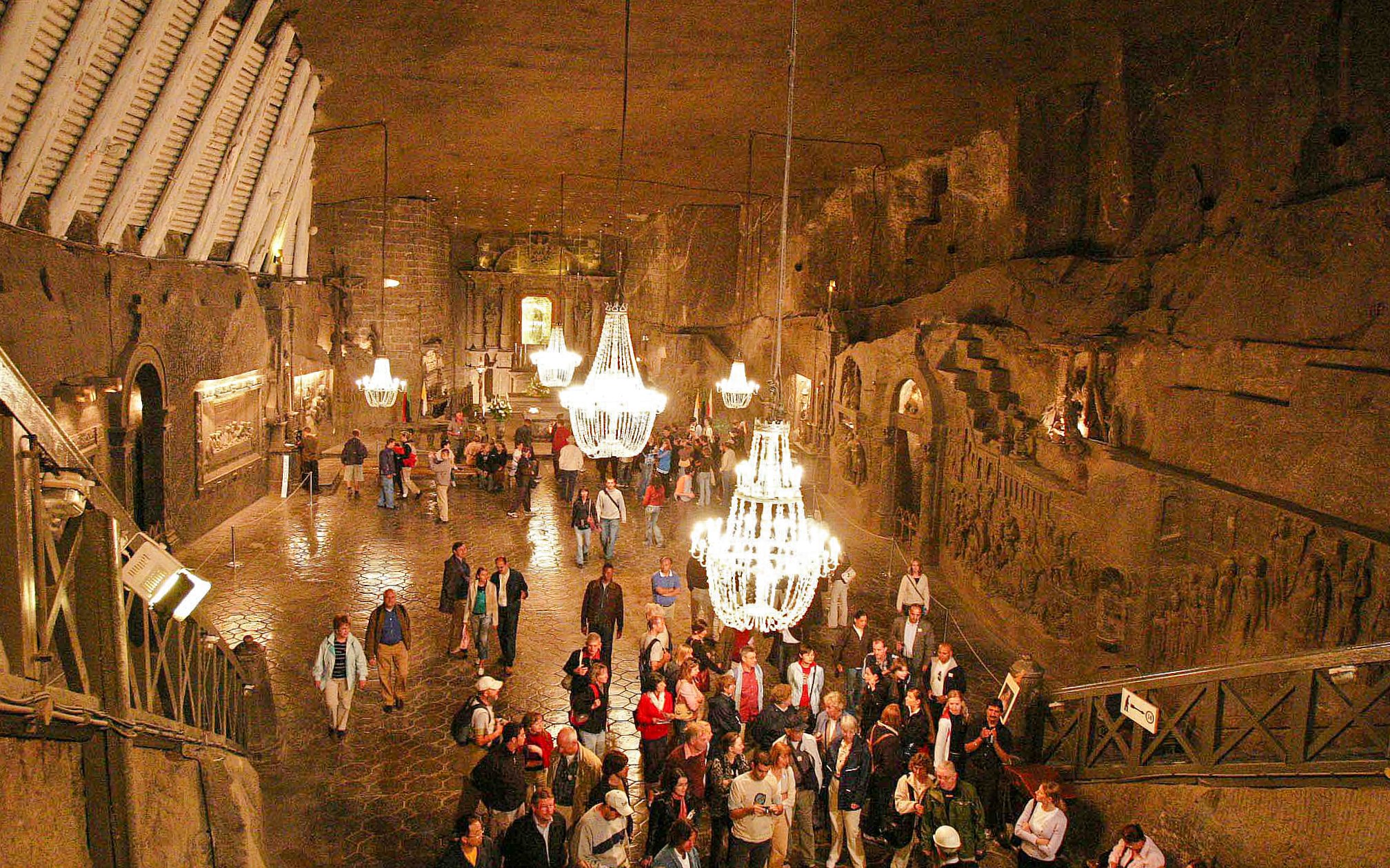 Visitors exploring the illuminated chambers of Wieliczka Salt Mine, Krakow, Poland.