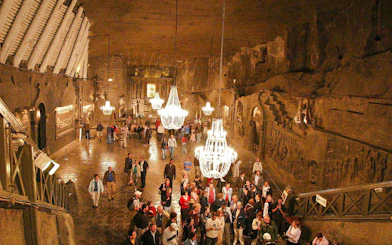 Visitors exploring the illuminated chambers of Wieliczka Salt Mine, Krakow, Poland.