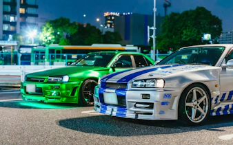 Two modified cars parked in Tokyo at night for the Fast & Furious Tokyo Drift III Experience.