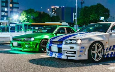 Two modified cars parked in Tokyo at night for the Fast & Furious Tokyo Drift III Experience.