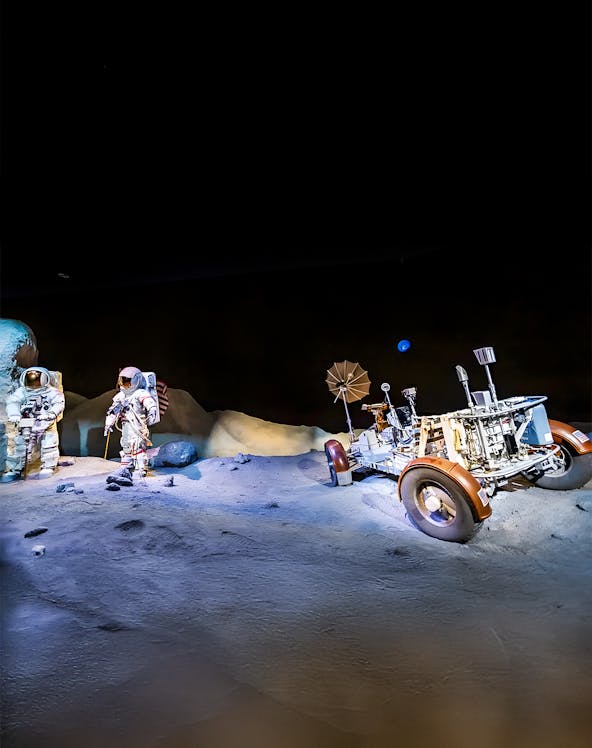 Astronauts and lunar rover exhibit at Houston Space Center.