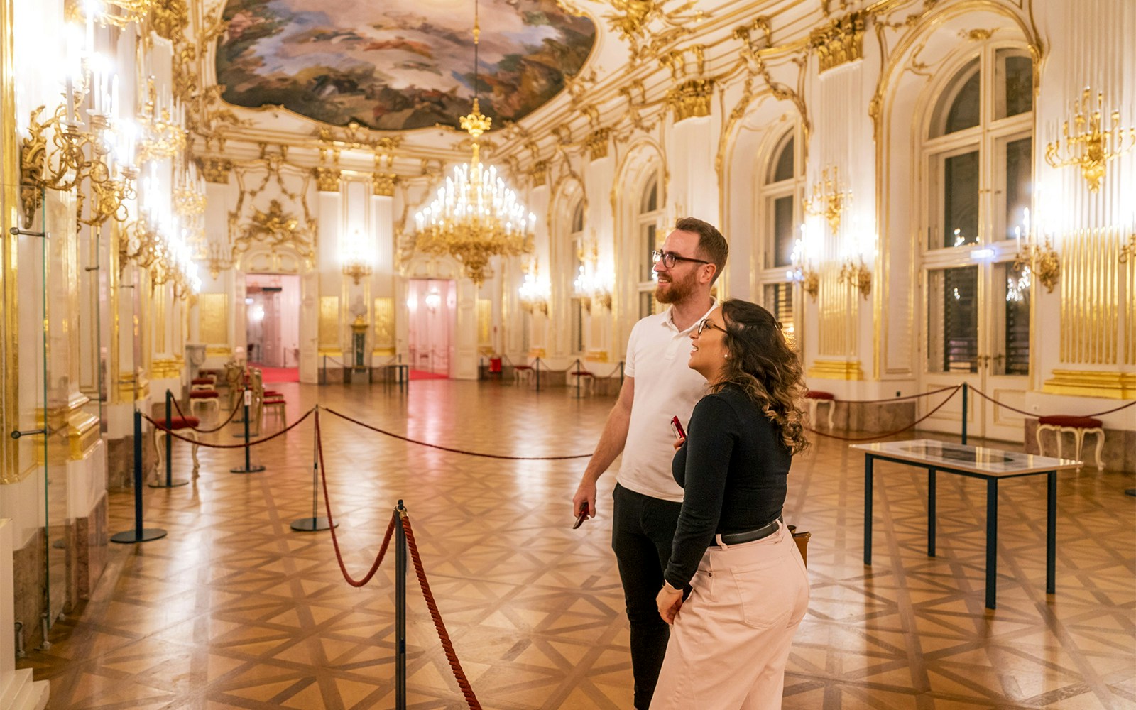 Visitors admiring the ornate interior of Schonbrunn Palace during a tour.