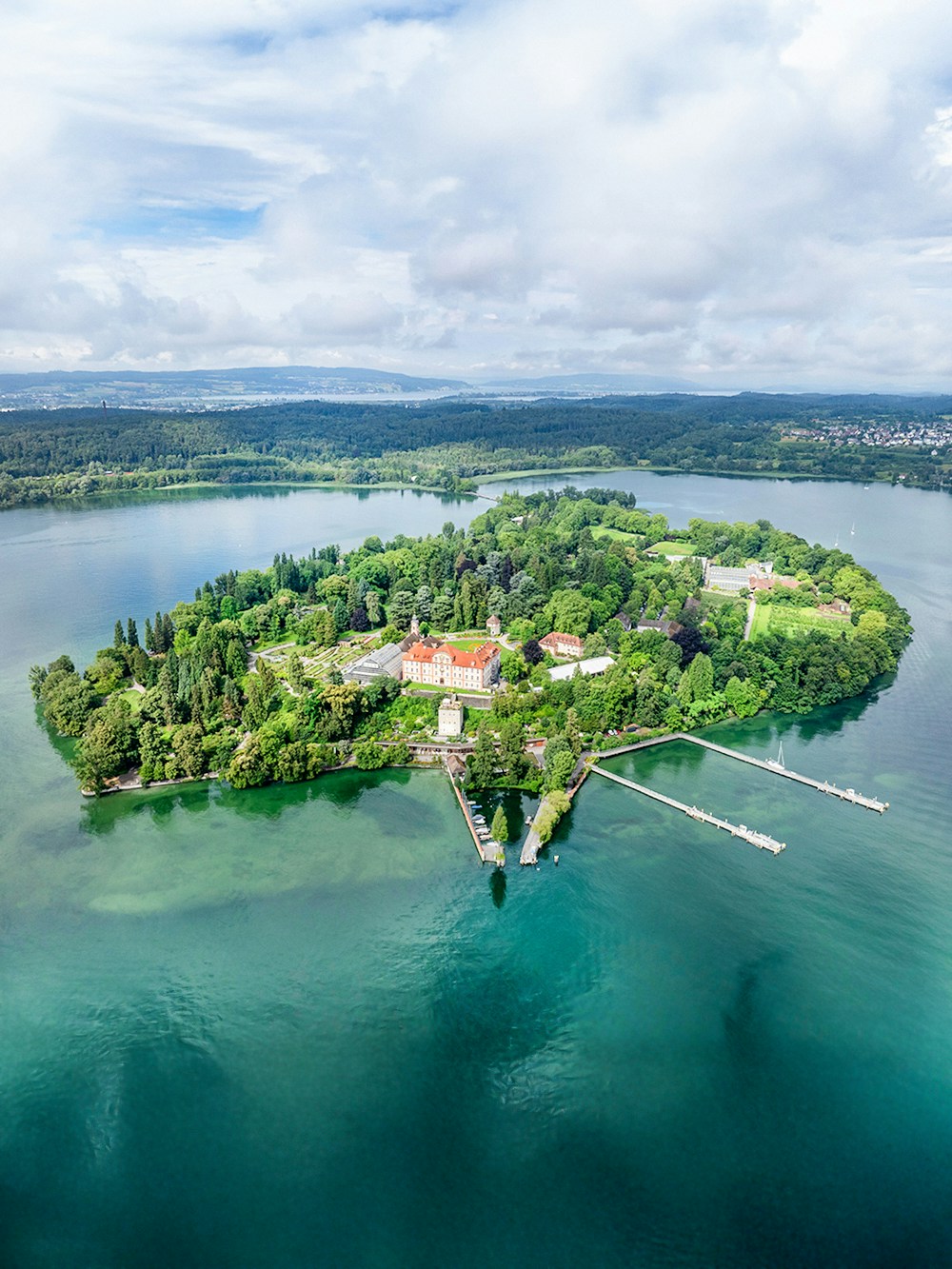 Aerial view of Mainau Flower Island on Lake Constance, surrounded by lush greenery and water.