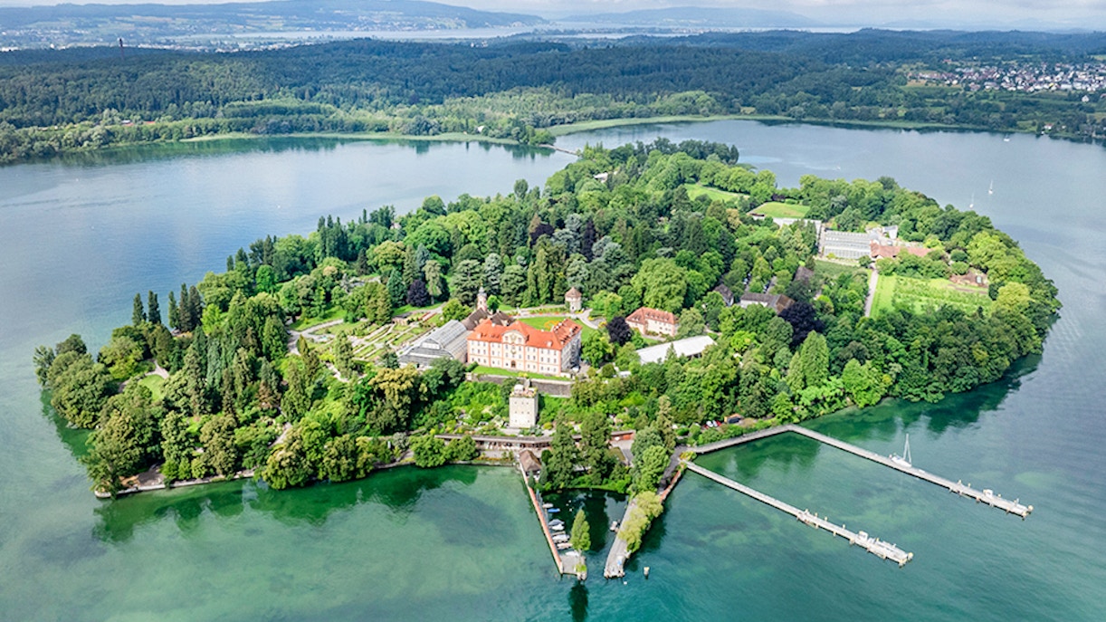 Aerial view of Mainau Flower Island on Lake Constance, surrounded by lush greenery and water.