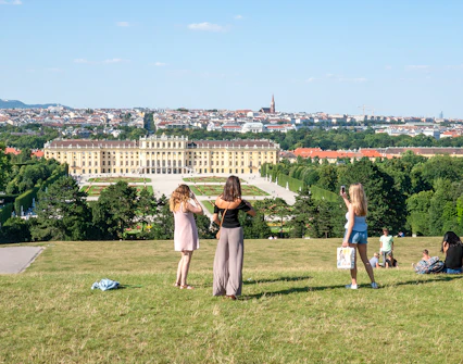 Schönbrunn Palace and gardens in Vienna with visitors enjoying the view.
