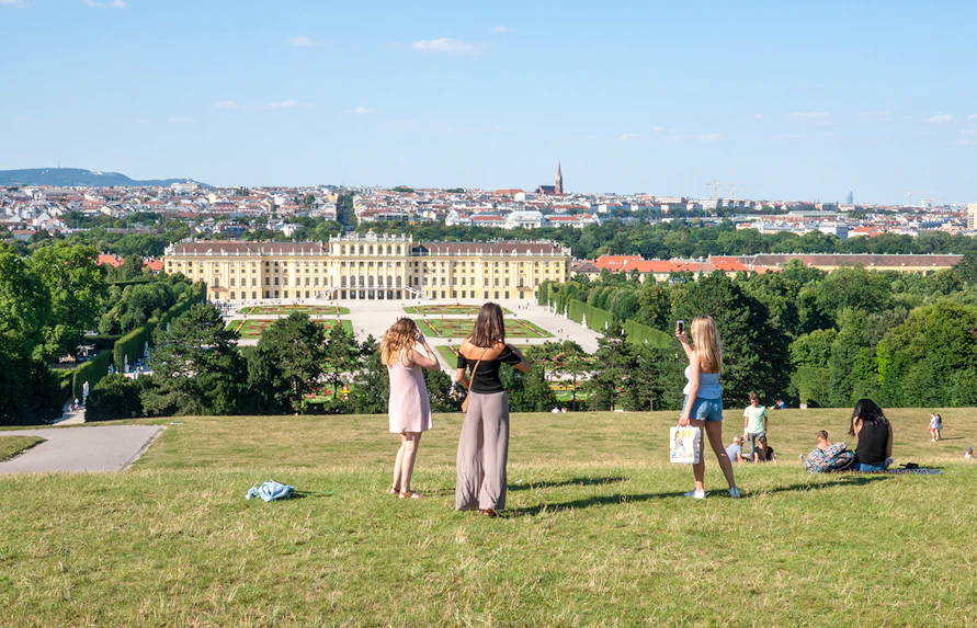 Schönbrunn Palace and gardens in Vienna with visitors enjoying the view.