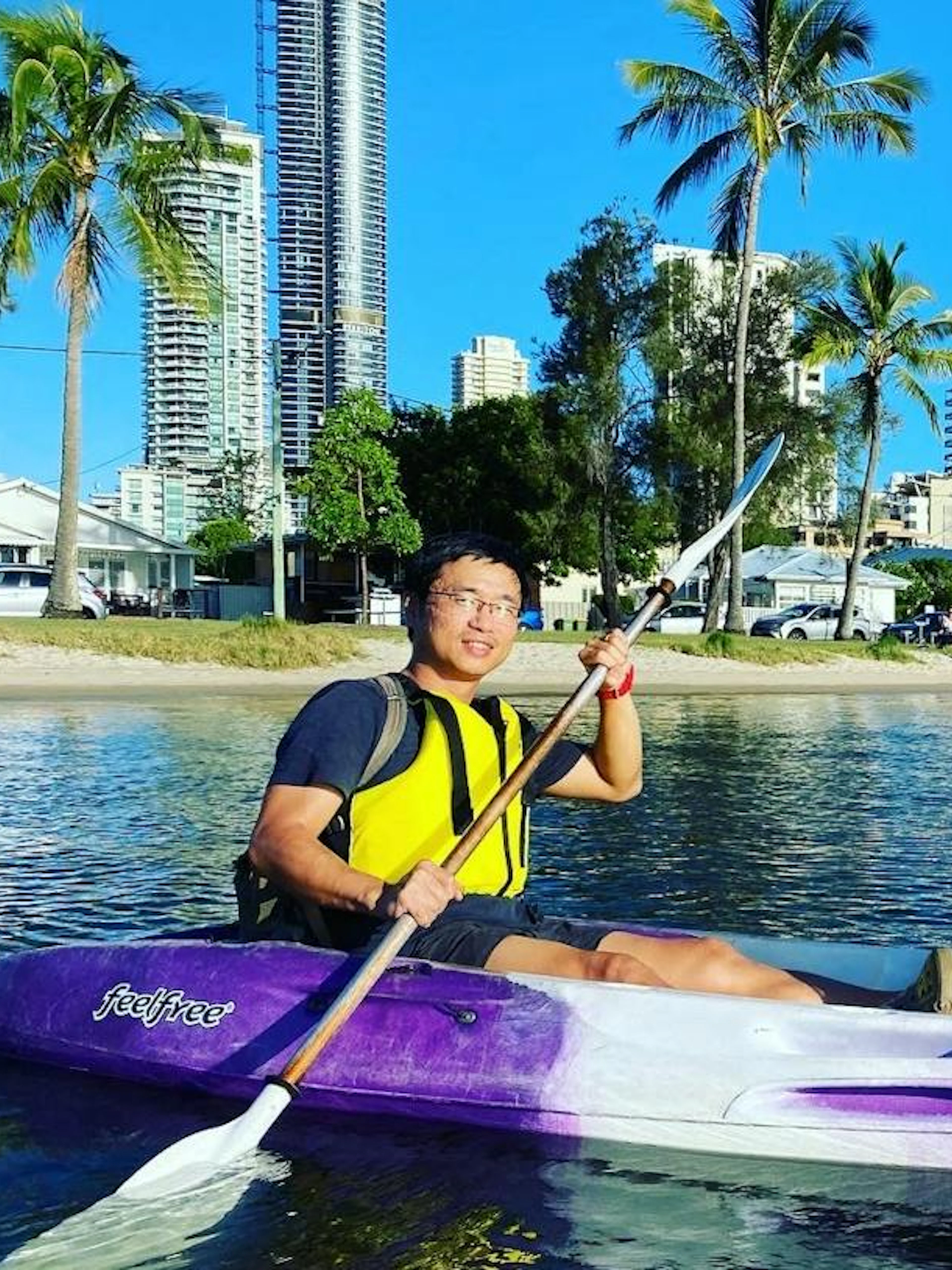 Kayakers paddling near Surfers Paradise skyscrapers on a sunset tour, Gold Coast.