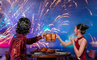 Couple enjoying dinner with fireworks on Paradise Pearl Island, Phu Quoc.