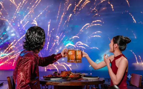 Couple enjoying dinner with fireworks on Paradise Pearl Island, Phu Quoc.