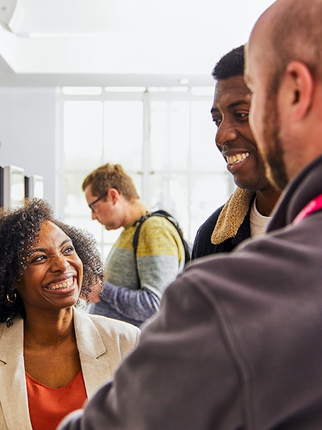 Guide assisting tourists with London Eye tickets at kiosk.