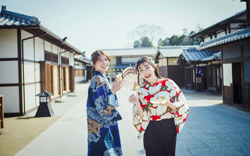 Visitors in traditional attire enjoying snacks at TOEI Kyoto Studio Park.