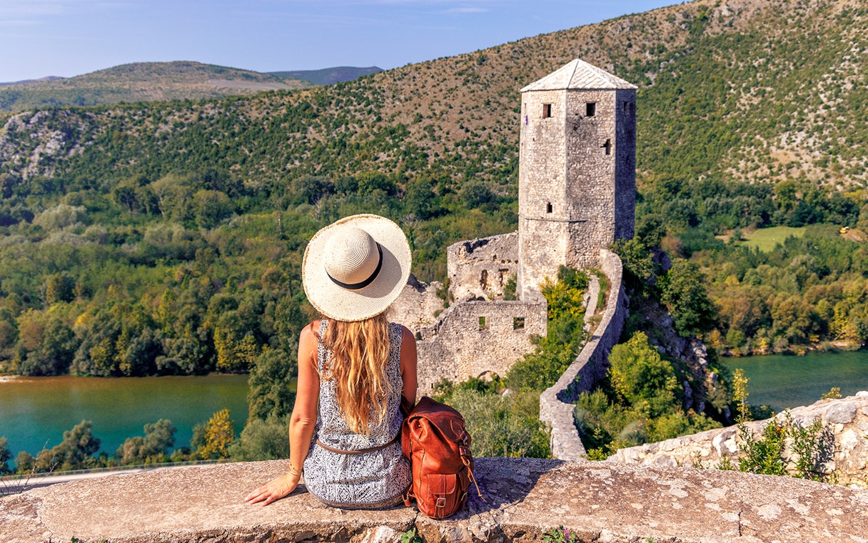Traveler overlooking historic tower and lush landscape on Mostar guided tour from Split to Trogir.