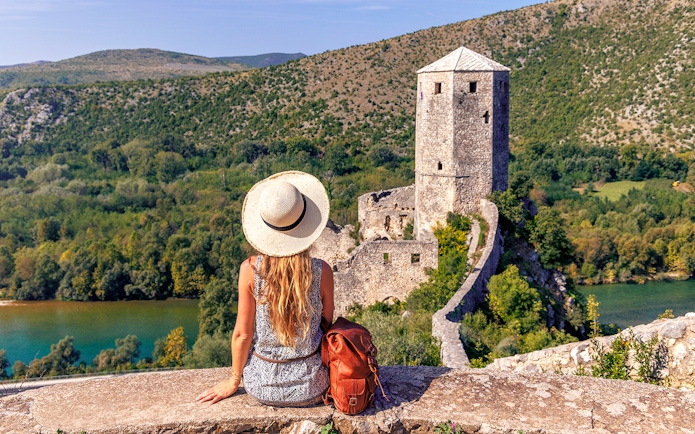 Traveler overlooking historic tower and lush landscape on Mostar guided tour from Split to Trogir.