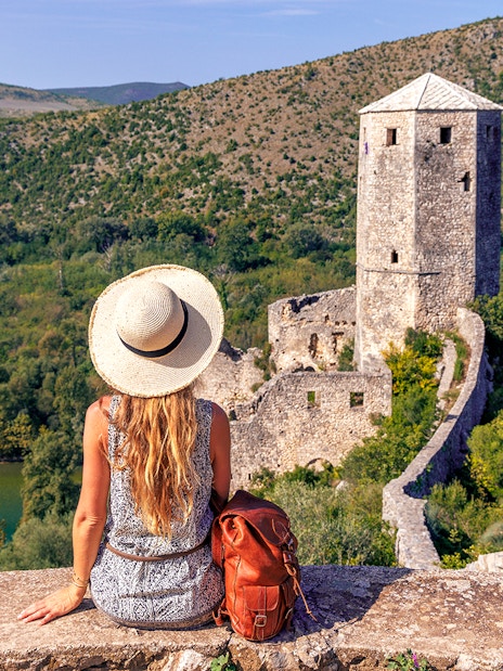 Traveler overlooking historic tower and lush landscape on Mostar guided tour from Split to Trogir.