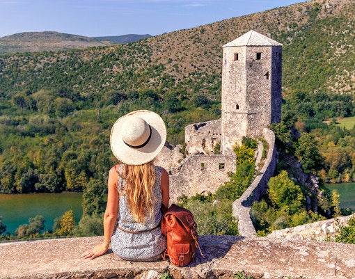Traveler overlooking historic tower and lush landscape on Mostar guided tour from Split to Trogir.