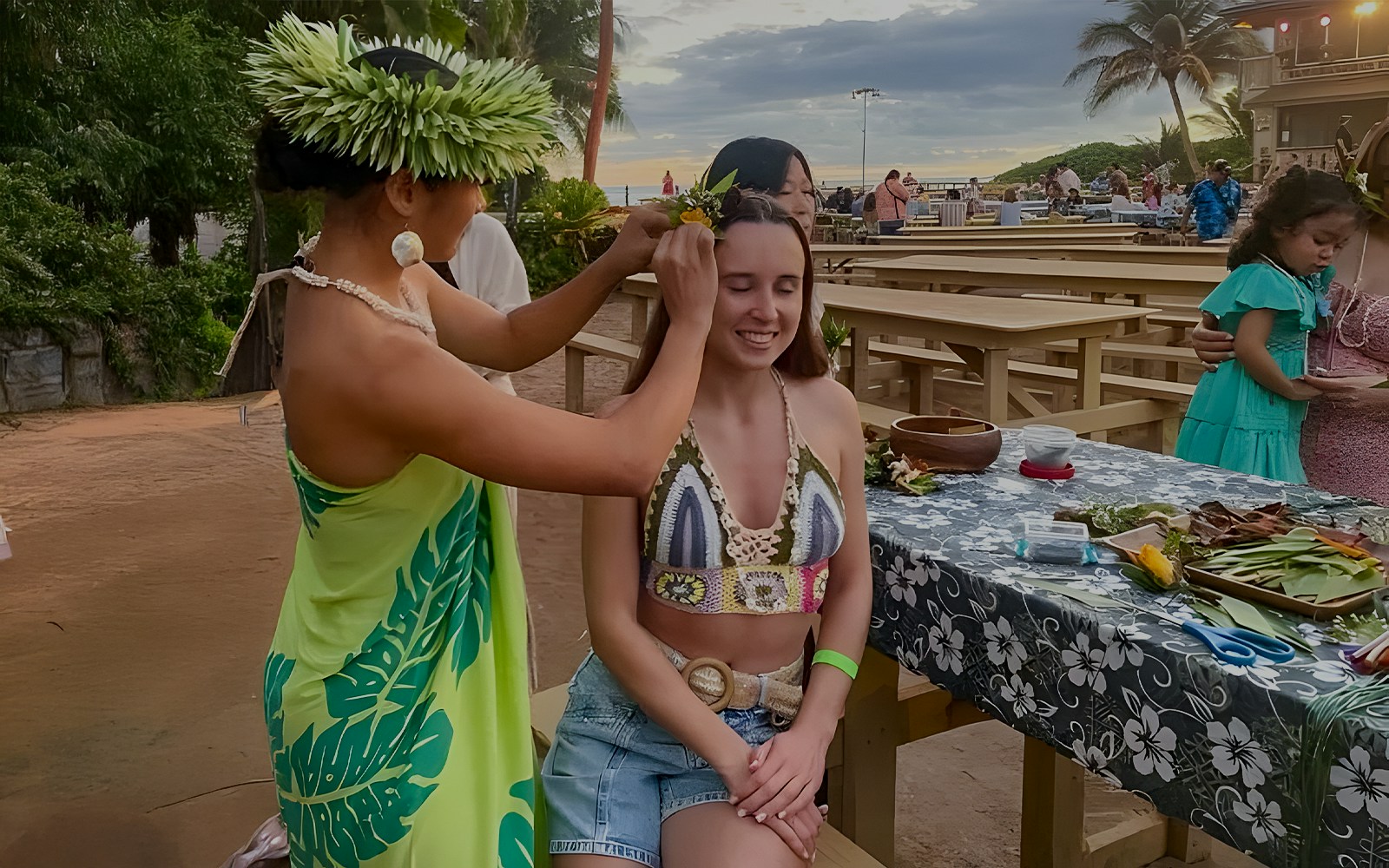 Woman receiving a flower crown at Germaine's Luau pre-show cultural activities.
