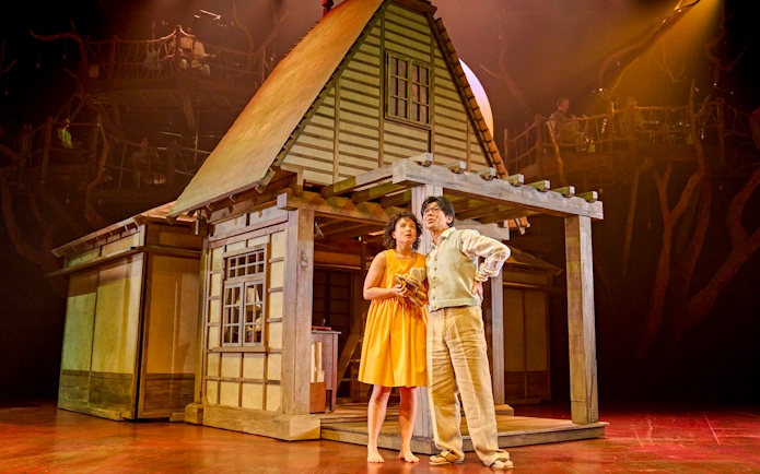 Stage actors in front of a traditional Japanese house set during My Neighbour Totoro production.
