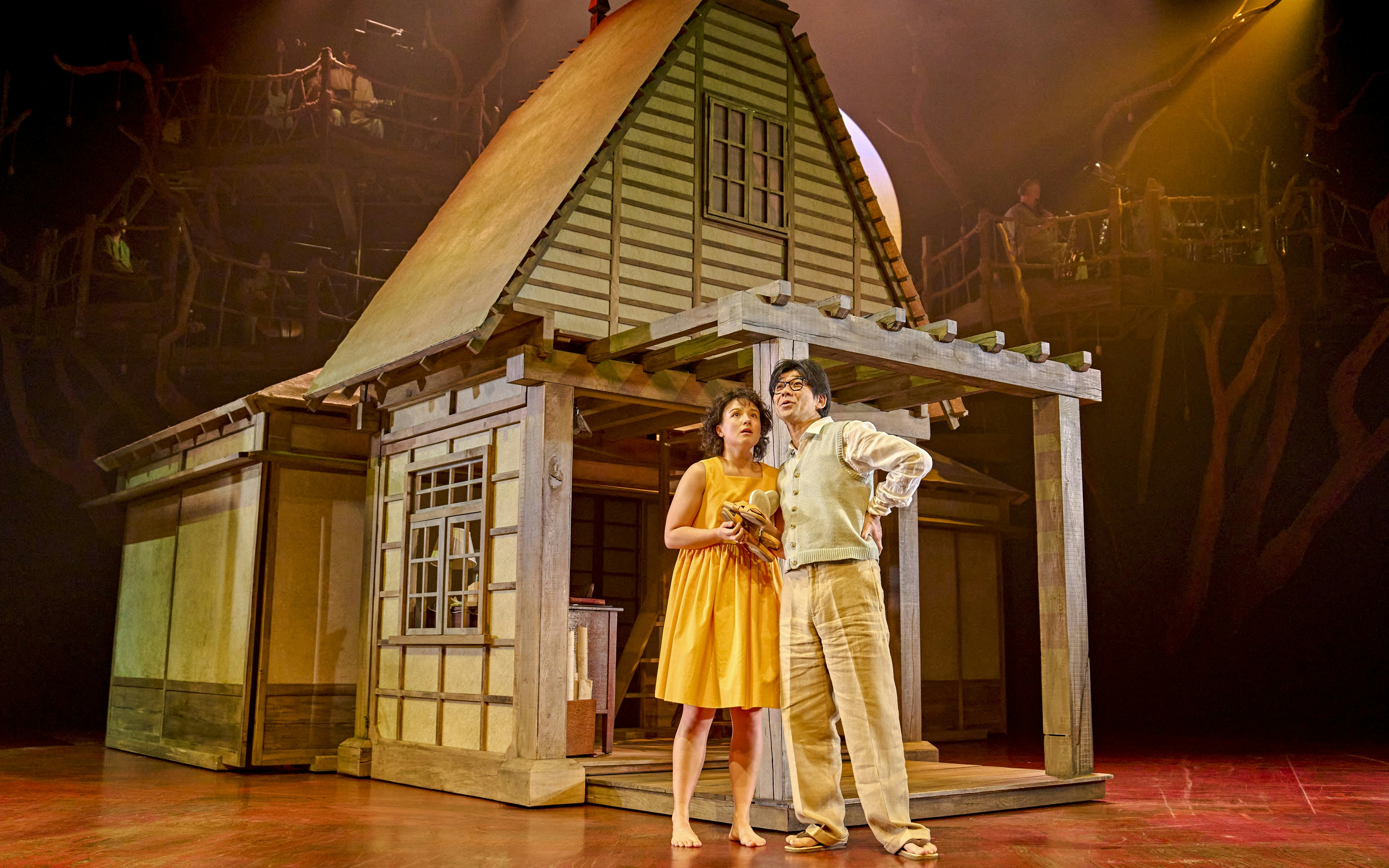 Stage actors in front of a traditional Japanese house set during My Neighbour Totoro production.