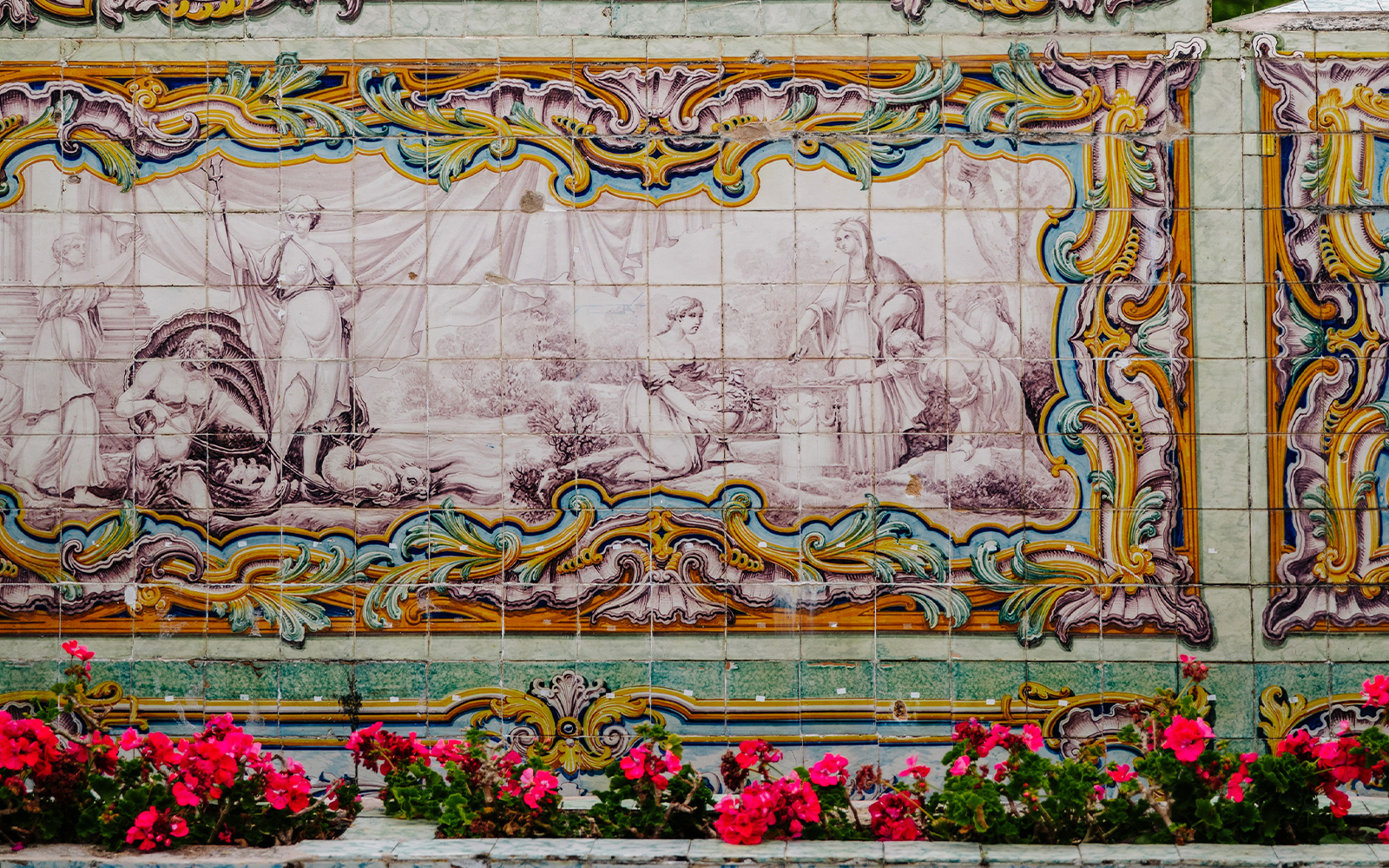 Tile artwork in the garden of the National Palace of Queluz, Portugal, with vibrant floral border.
