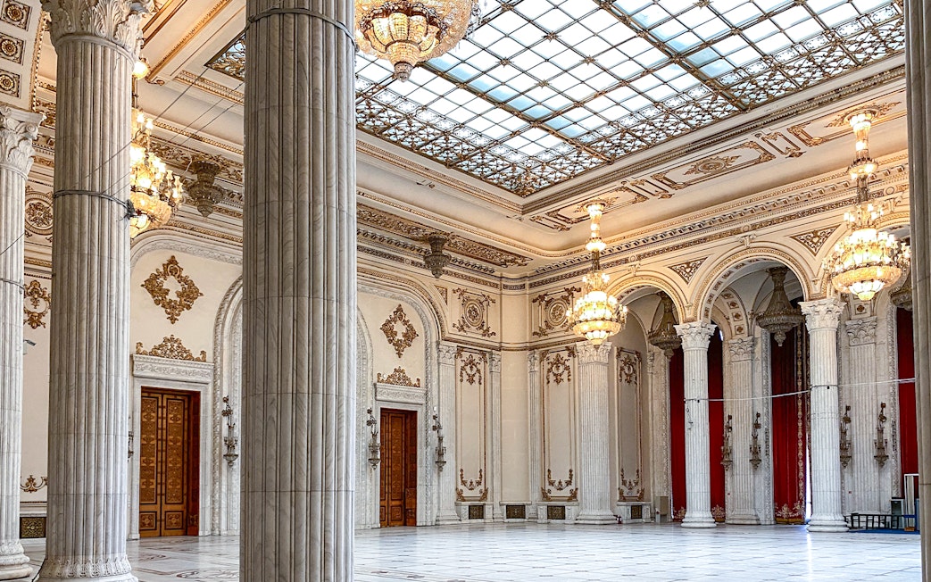 Grand hall with chandeliers and columns inside the Palace of Parliament, Bucharest, Romania.