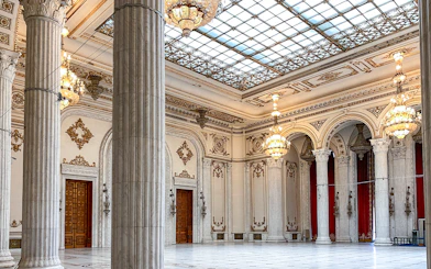 Grand hall with chandeliers and columns inside the Palace of Parliament, Bucharest, Romania.