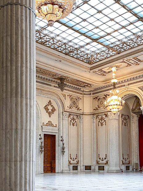 Grand hall with chandeliers and columns inside the Palace of Parliament, Bucharest, Romania.