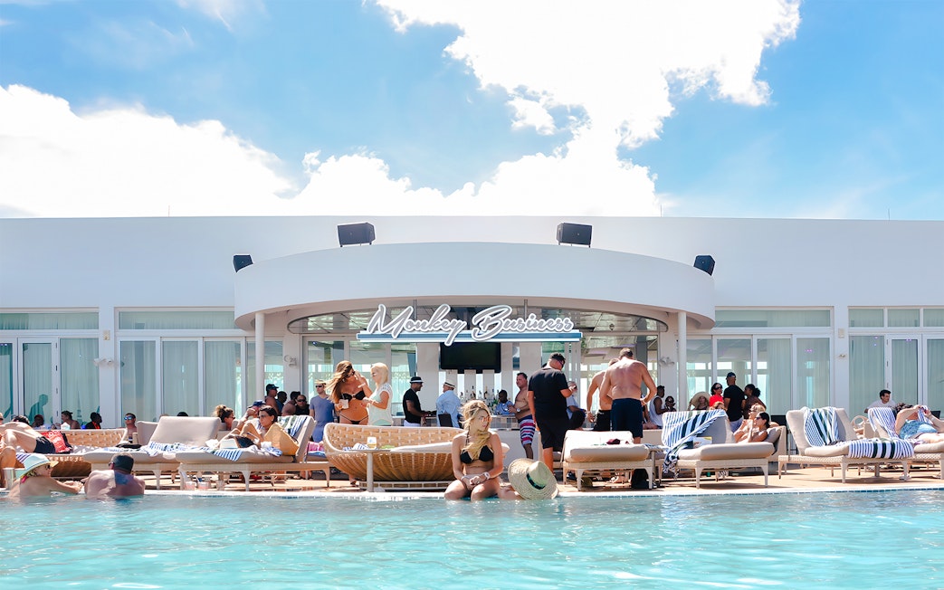 Poolside bar scene at Monkey Business in Bimini, Bahamas with people relaxing and socializing.
