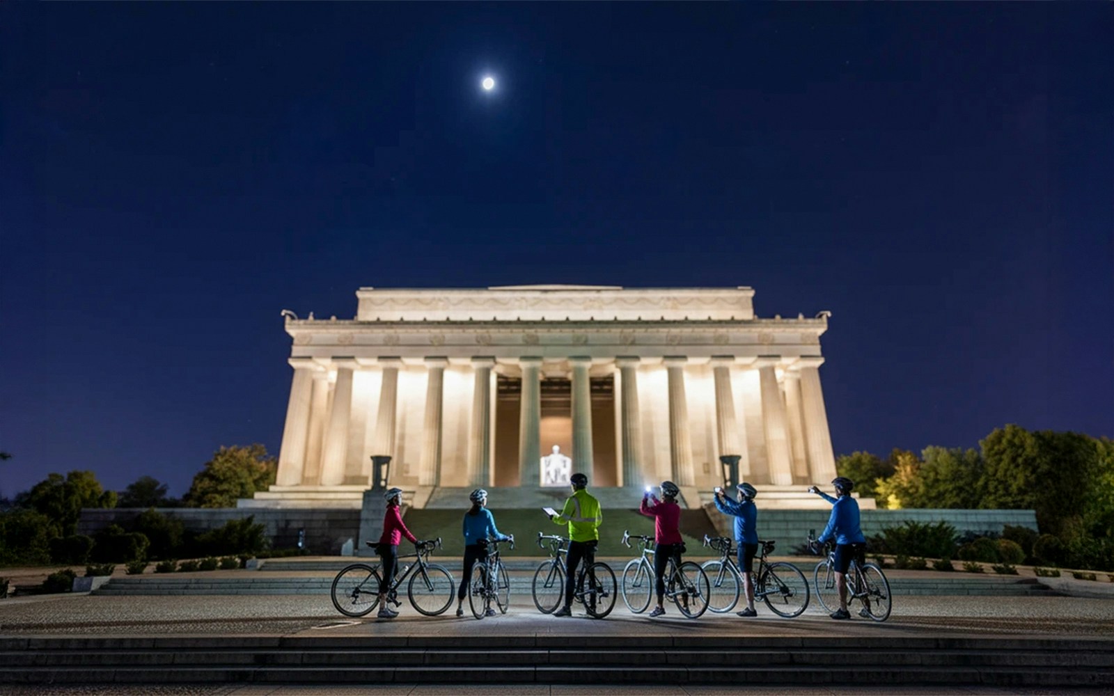 Tourists biking at night near the illuminated Lincoln Memorial, Washington D.C.