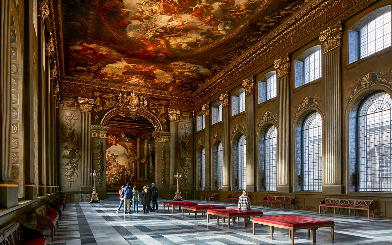Visitors admiring the ornate ceiling of the Painted Hall at the Old Royal Naval College.