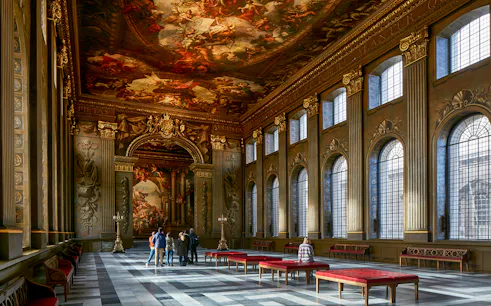 Visitors admiring the ornate ceiling of the Painted Hall at the Old Royal Naval College.