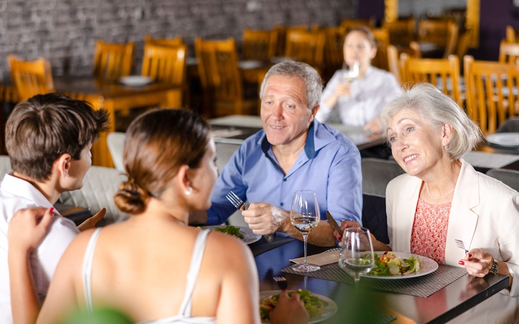 Group enjoying lunch at a restaurant near Alpsee Lake, Germany.