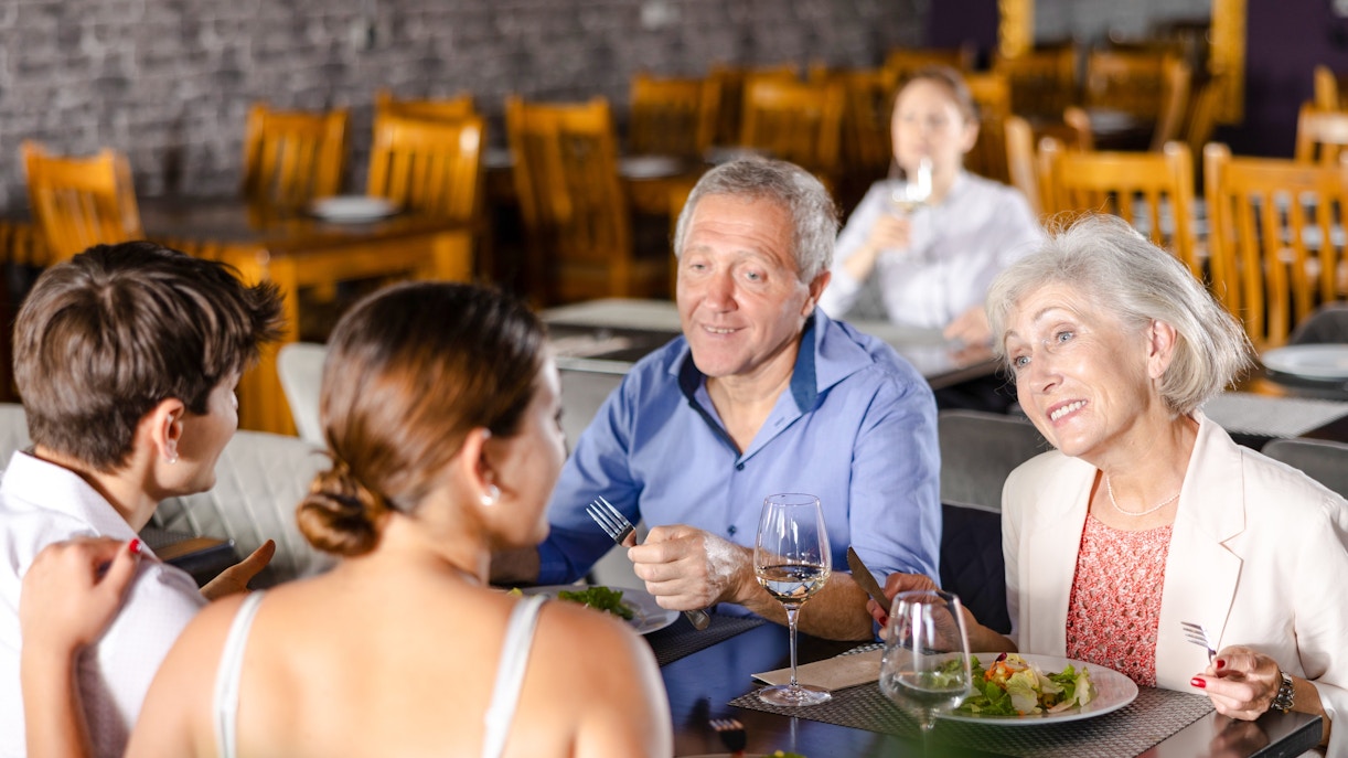 Group enjoying lunch at a restaurant near Alpsee Lake, Germany.