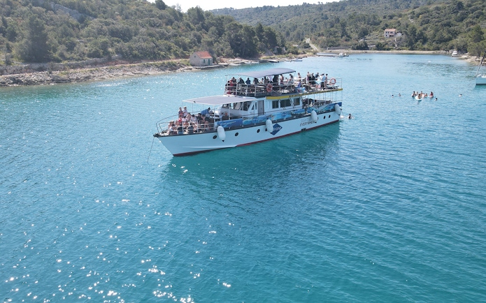 Cruise ship on Blue Lagoon near Split with passengers enjoying the view.
