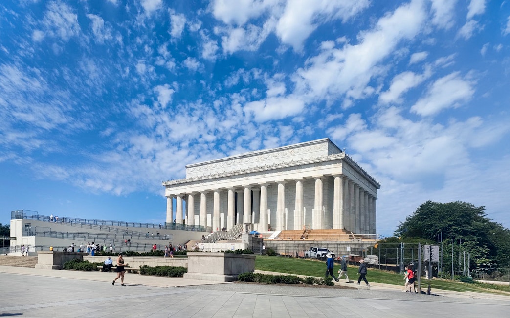 Lincoln Memorial with visitors in Washington D.C. under a clear blue sky.