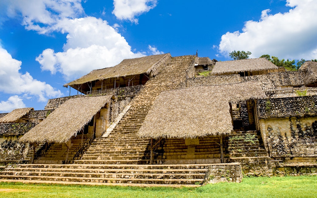 Ancient Mayan pyramid with thatched roofs at Ek Balam, Mexico.