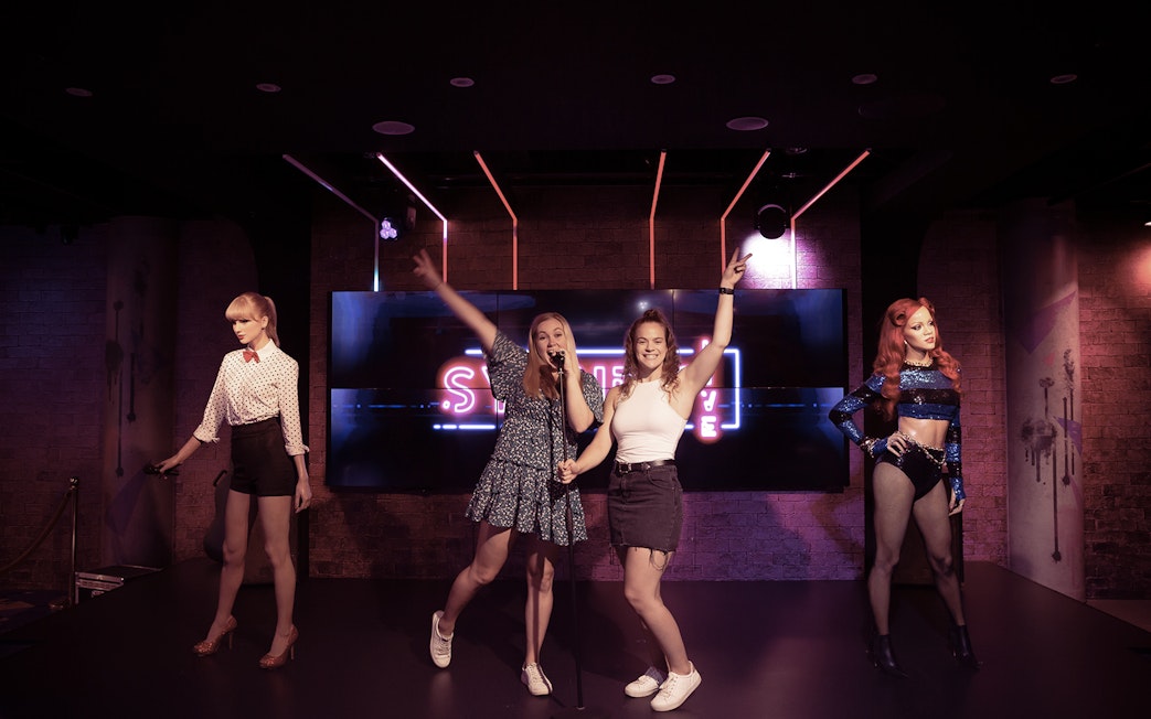 Visitors posing with wax figures at Madame Tussauds Sydney.