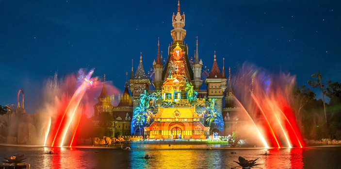VinWonders castle illuminated with colorful lights and water fountains at night.