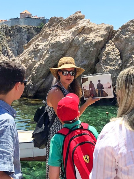 Tour guide showing Game of Thrones scene to group by Dubrovnik's historic walls.