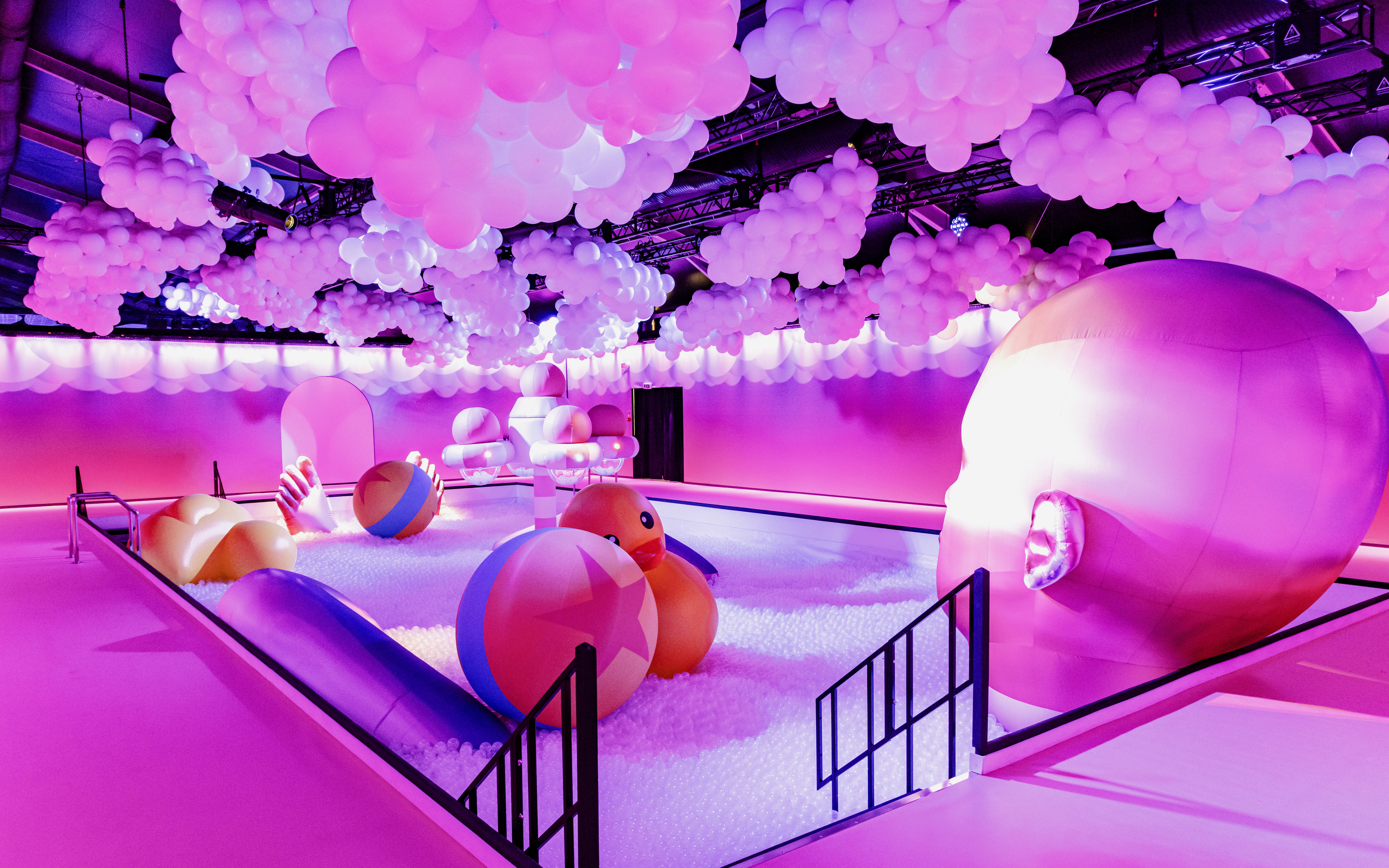 Interactive bubble-themed room with colorful balls and large head sculpture at Bubble Planet, Cologne.