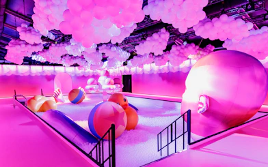 Interactive bubble-themed room with colorful balls and large head sculpture at Bubble Planet, Cologne.