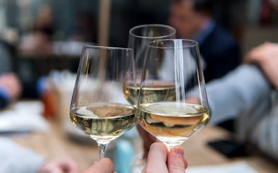 Three people toasting with white wine glasses during Porto Petisco Crawl.