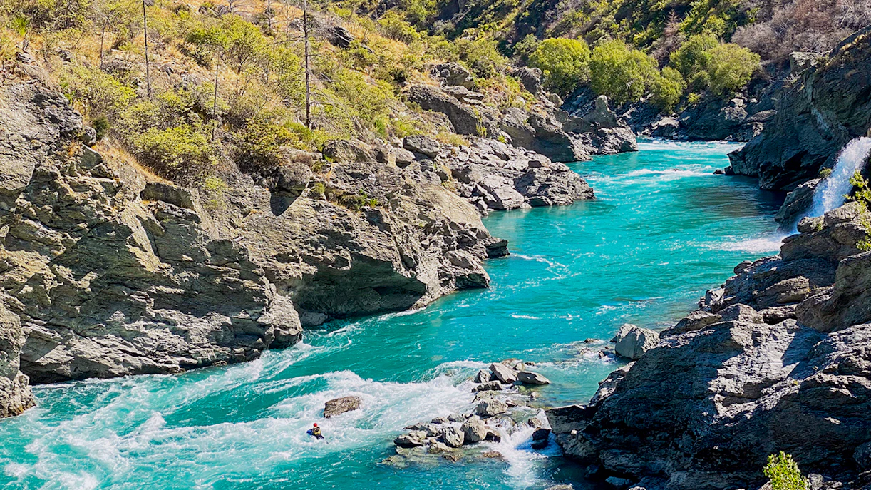 Kawarau River flowing through rocky Kawarau Gorge with a kayaker navigating rapids.