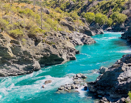 Kawarau River flowing through rocky Kawarau Gorge with a kayaker navigating rapids.