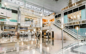 Plaza Premium Lounge entrance at Dallas Fort Worth International Airport with escalator.