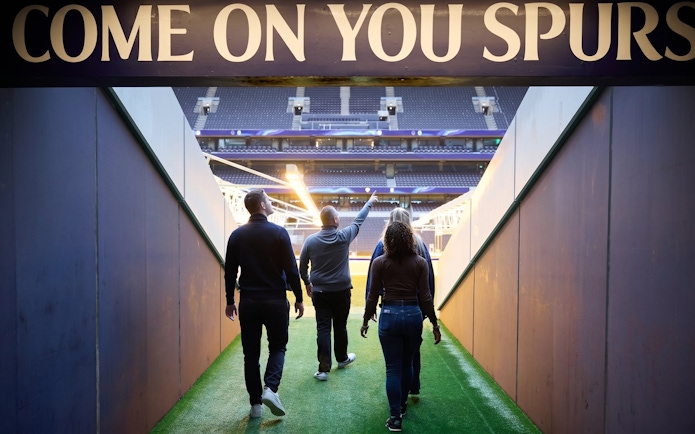 Visitors walking through the tunnel at Tottenham Hotspur Stadium.