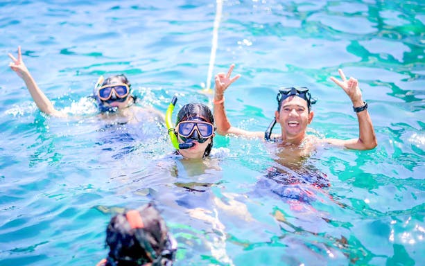 Snorkelers enjoying turquoise waters in Khai Islands.