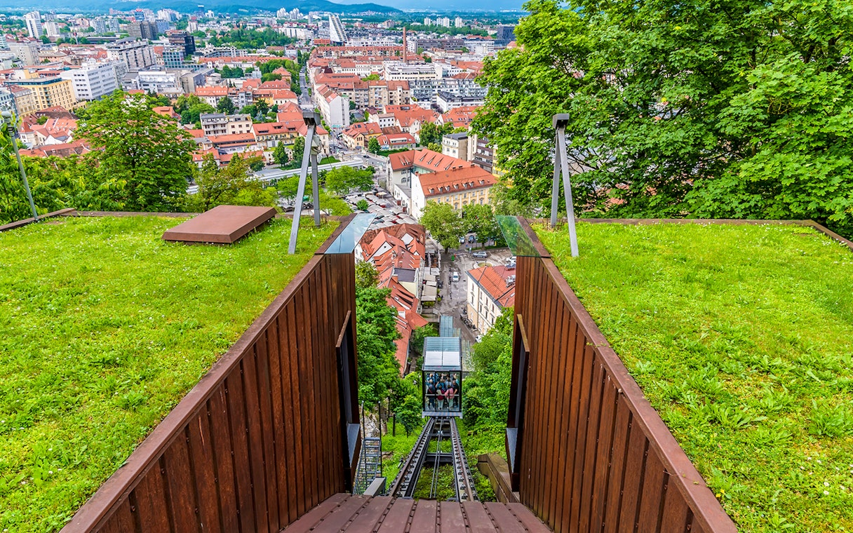 Funicular railway leading to Ljubljana Castle with city view below.
